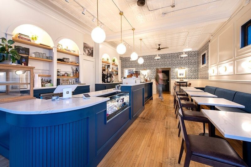 Bright neighborhood café with counter seating and tables for local patrons