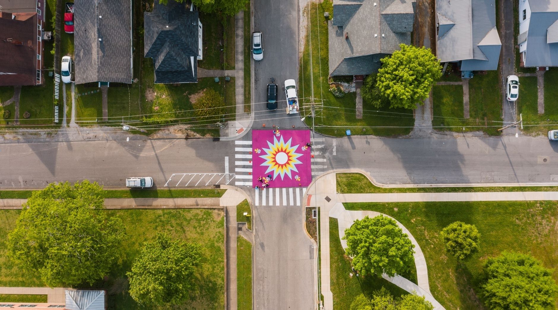 Aerial view of a colorful painted mural at a residential intersection